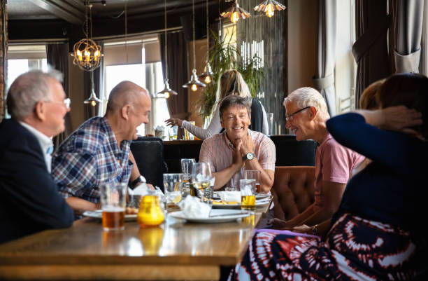 istock Men and Women Laughing Over Pub Lunch 1166265282