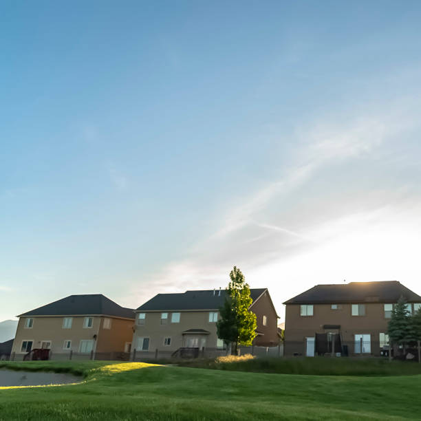 istock Square Multi storey homes with white walls and fences overlooking a golf course 1166265378