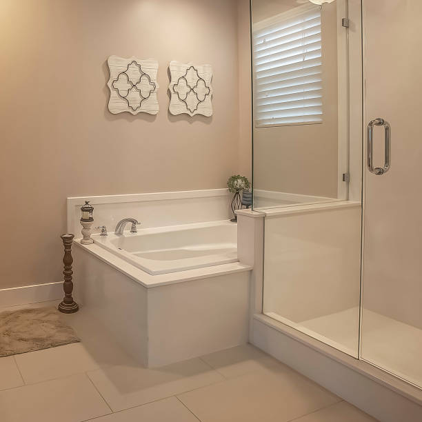 istock Square frame Bathroom interior with a shower stall beside the built in bathtub 1166265894