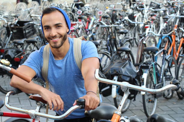 Handsome ethnic man in bicycle parking lot.