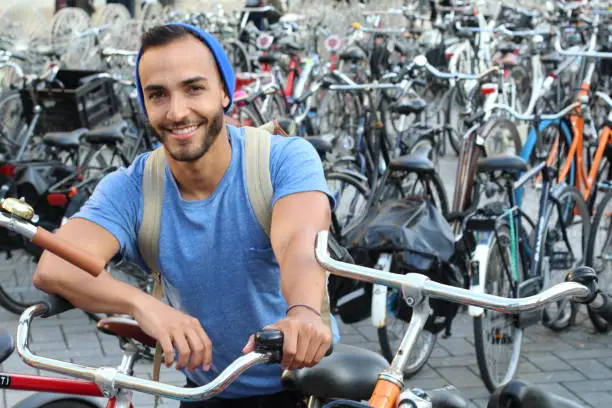 Photo of Handsome ethnic man in bicycle parking lot