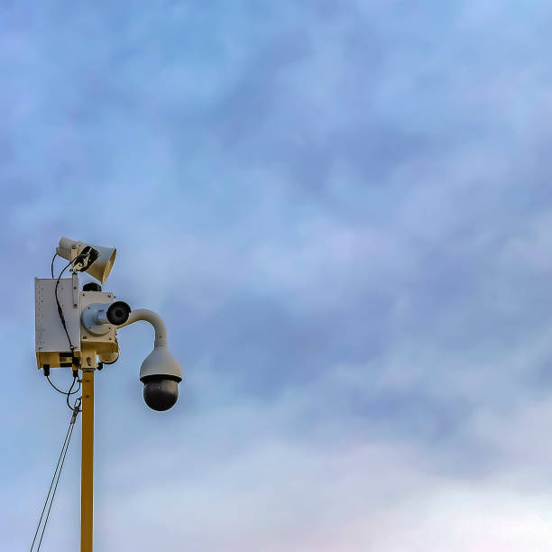 istock Outdoor security camera isolated against a cloudy blue sky background 1166265908