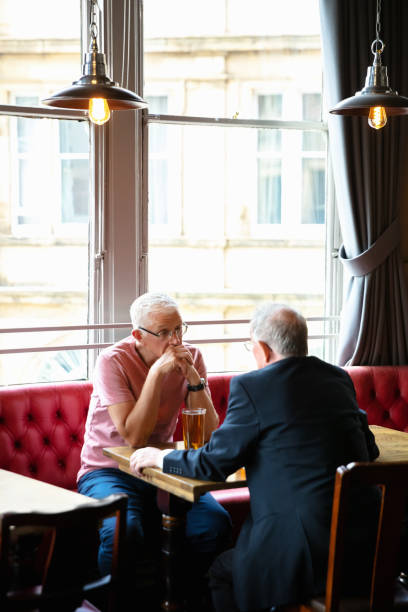 istock Senior Friends Having Quiet Conversation in Pub 1166265990