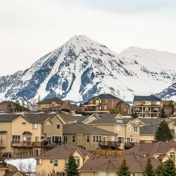 istock Square frame Hill homes with rugged snow covered mountain peak in the background 1166267308