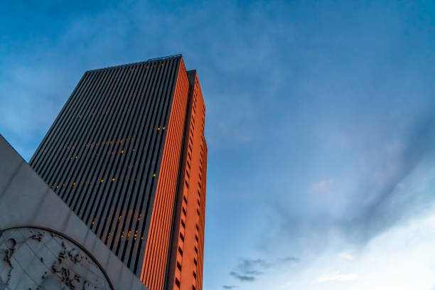 istock Building with gray and orange exterior wall viewed from below against cloudy sky 1166267368