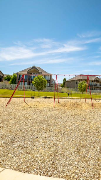 istock Vertical frame Playground with swings and picnic pavilion under blue sky on a sunny day 1166267381