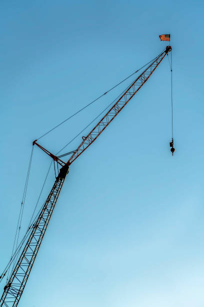 istock Construction crane viewed from below with blue sky background on a sunny day 1166267695