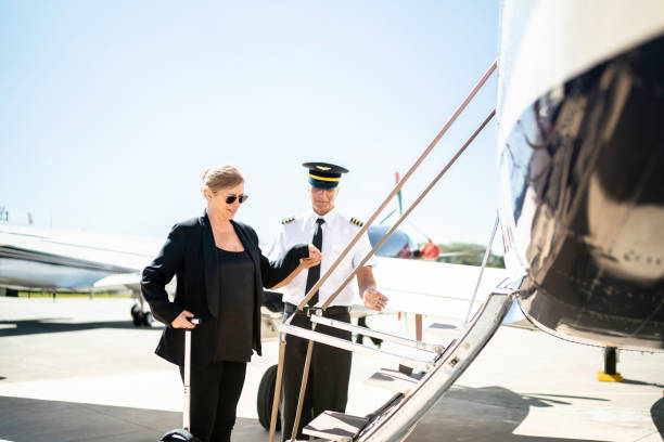 businesswoman boarding into flight in a corporate jet - entering airplane imagens e fotografias de stock