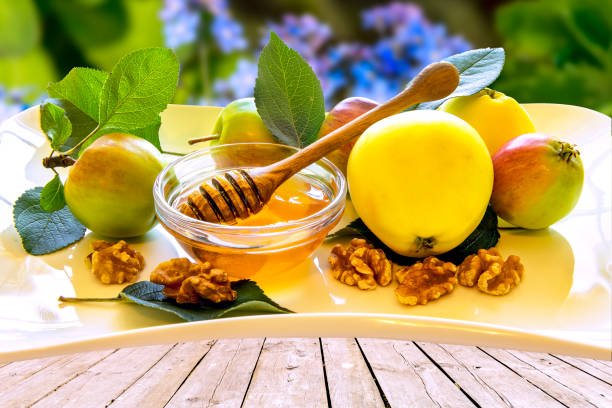 istock Honey, apples, walnuts  on wooden table, and background with blurred defocused nature 1166269590