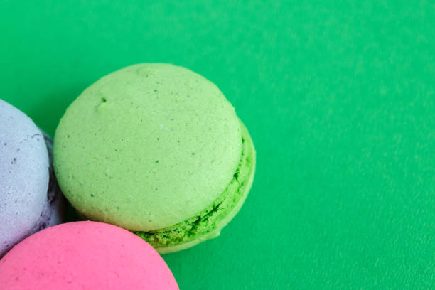 istock colorful macarons or macaroons cookies on green background. top view 1166269958