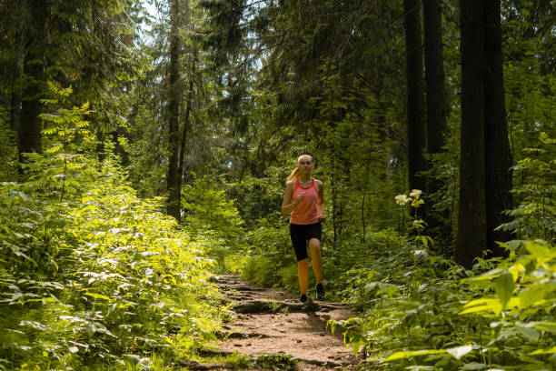 istock young woman jogging in a mountain forest 1166270049
