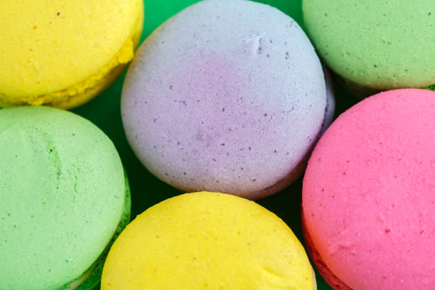 istock colorful macarons or macaroons cookies on green background. top view 1166270829