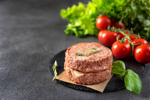 istock Two raw vegan patties on dark grey background 1166270918