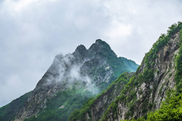 istock High rocky mountain peak in the clouds. 1166270992