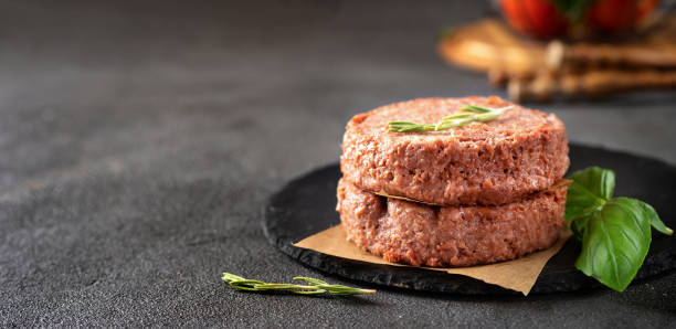istock Two raw vegan patties on dark grey background 1166271264