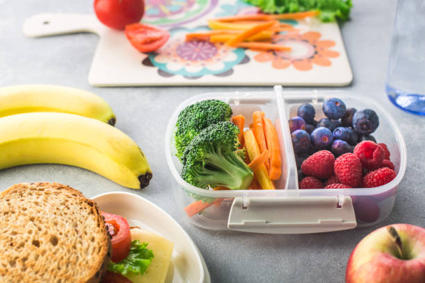 午前中に学校に健康的な昼食を与える母 - child human hand sandwich lunch box ストックフォトと画像