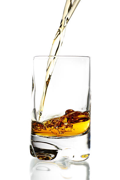 istock Clear glass with golden liquid pouring in 116627472