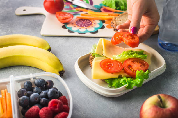 午前中に学校に健康的な昼食を与える母 - child human hand sandwich lunch box ストックフォトと画像