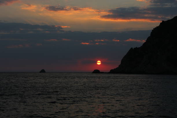 Sunset over sea with mountains