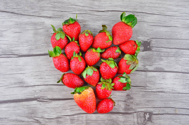 istock Strawberries over wooden background with Love shape 1166278089