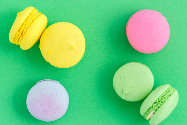 istock colorful macarons or macaroons cookies on green background. top view 1166279850