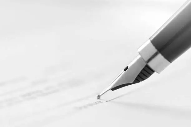 Photo of signing a document with an ink pen fountain
