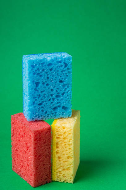istock Stack geometric blocks construction abstract sponges in red, yellow, blue colors, on green paper background, copy space 1166283693