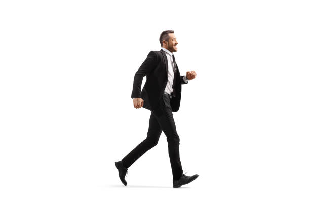 istock Businessman in a black suit running and smiling 1166284012