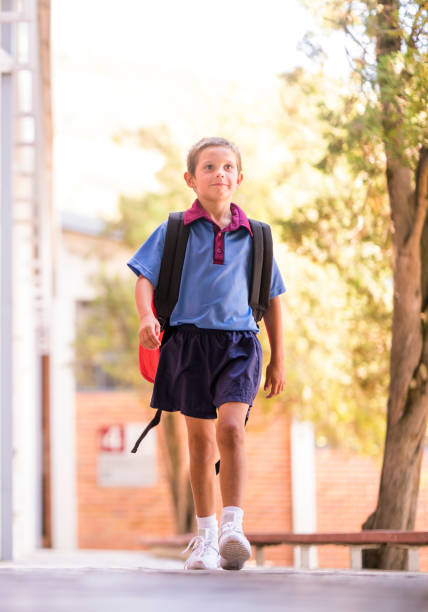 istock Full length of schoolboy walking on footpath 1166285053