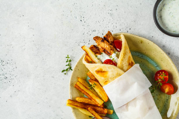 gyros souvlaki wraps in pita bread with chicken, potatoes and tzatziki sauce. - souvlaki imagens e fotografias de stock