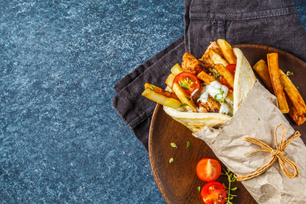 gyros souvlaki wraps in pita bread with chicken, potatoes and tzatziki sauce. - opa! souvlaki of greece imagens e fotografias de stock