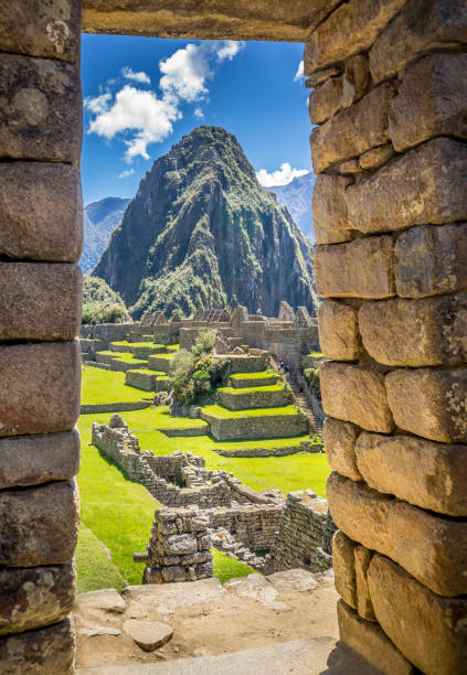 le rovine inca di machu picchu, patrimonio mondiale dell'unesco attraverso la cornice del muro di pietra - machu picchu foto e immagini stock