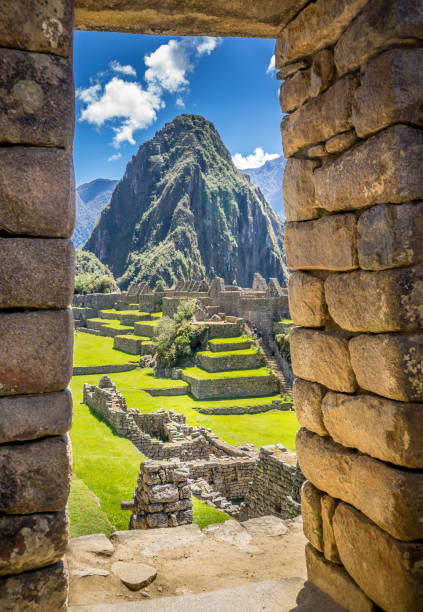 The Inca ruins of Machu Picchu, UNESCO World Heritage Site through the frame of stone wall The Inca ruins of Machu Picchu, UNESCO World Heritage Site through the frame of stone wall machu picchu photos stock pictures, royalty-free photos & images
