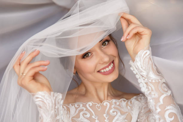 wedding portait of happy bride. gorgeous beauty young bride portrait. beautiful bride with wedding makeup in white wedding veil. bridal fashion model posing in interior. - hairstyle love wedding photography imagens e fotografias de stock