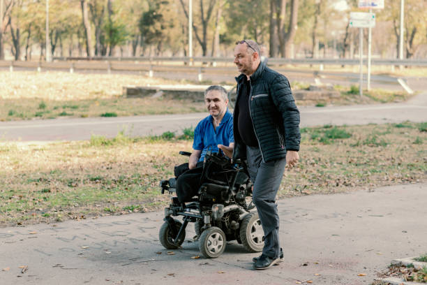 istock Two Men with Physical Disabilities in the Move are Having a Conversation on a Autumn Day Near in the Park 1166292202