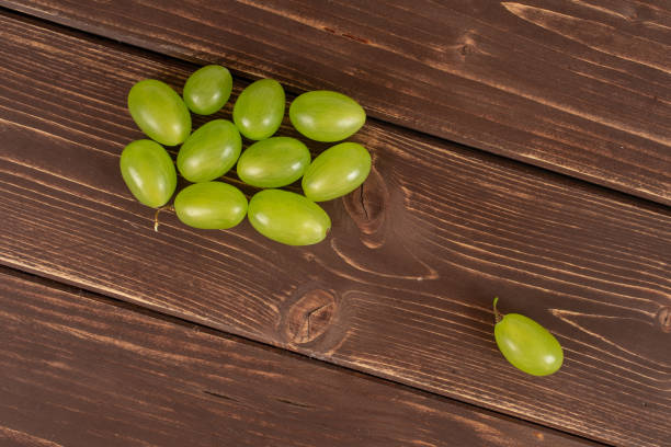 fresh green grape on brown wood - luminant imagens e fotografias de stock