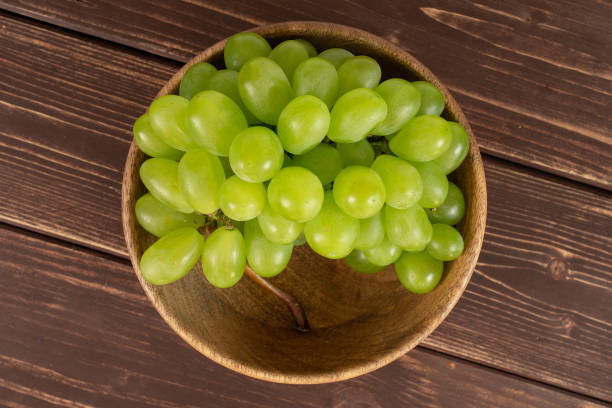 Fresh green grape on brown wood