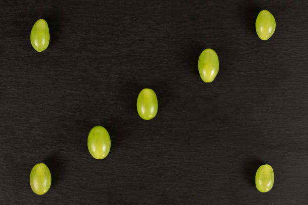 uva verde fresca su pietra grigia - luminant foto e immagini stock
