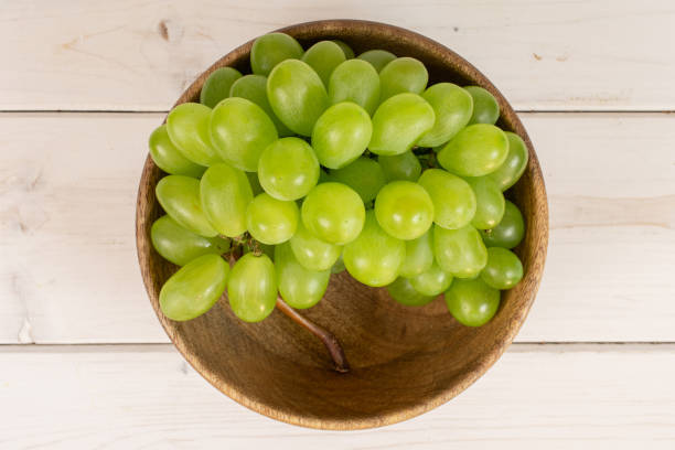 fresh green grape on grey wood - luminant imagens e fotografias de stock