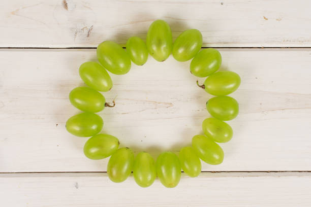 fresh green grape on grey wood - luminant imagens e fotografias de stock