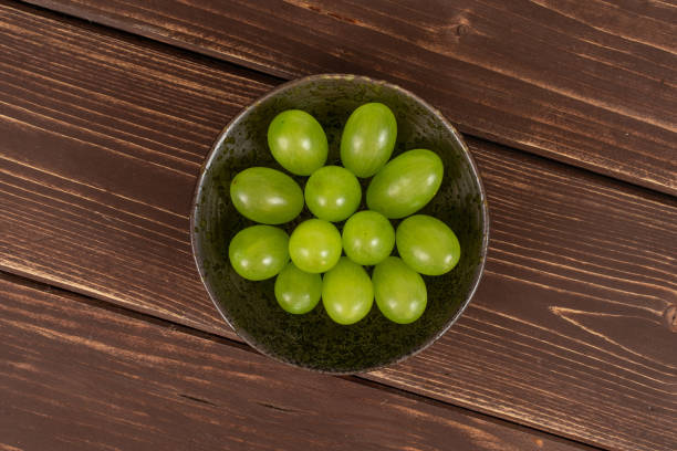 fresh green grape on brown wood - luminant imagens e fotografias de stock