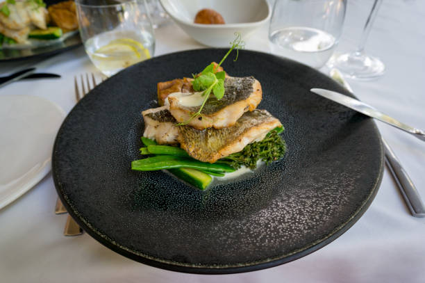 istock Dark plate with grilled fish fillets and green vegetables 1166298403