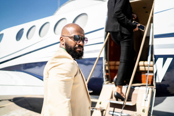 retrato de un hombre de negocios embarcando en un jet corporativo - millonario fotografías e imágenes de stock