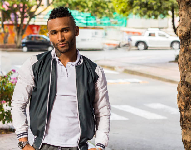 istock young man watching the camera walking by teh side walk 1166305014