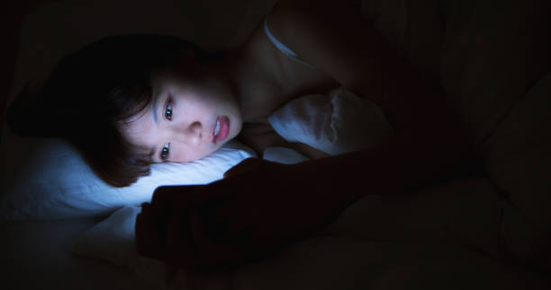 istock Woman Use Phone On The Bed at night 1166307108