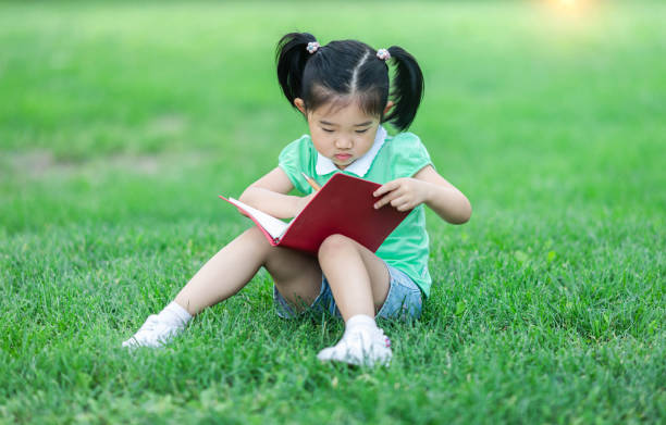istock Cute little girl learning on the lawn 1166309183