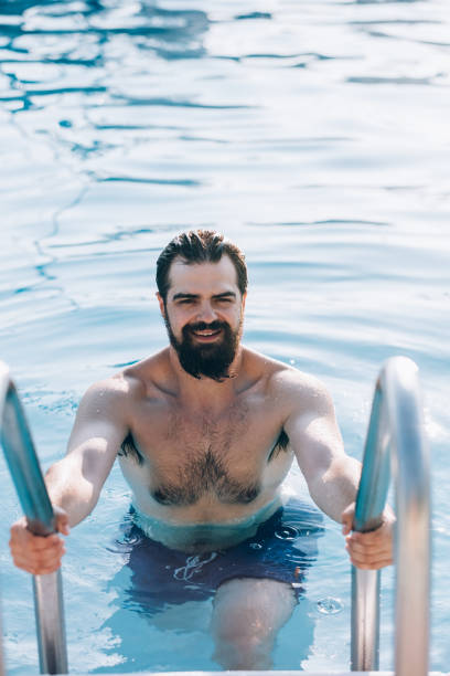 istock Millennial man  at the outdoor pool 1166311919