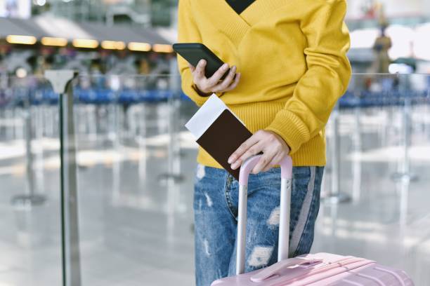 istock Passenger checking flight status and make a self check-in on smartphone at the airport, Traveller waiting for boarding call at terminal. Tourist arrive at destination, Travel concept. 1166312983
