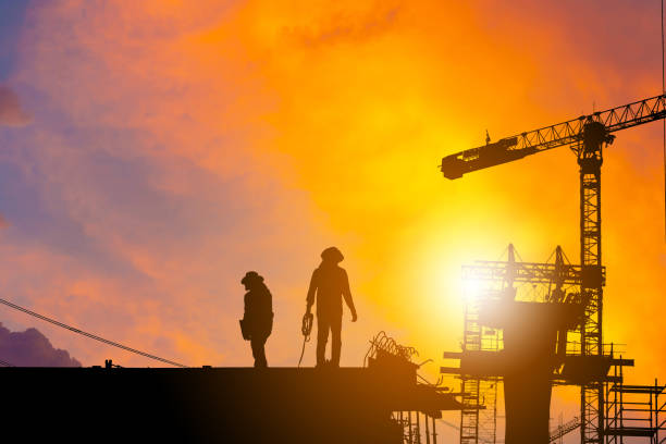 istock Silhouette of Worker on building construction site at sunset in evening time. 1166317140