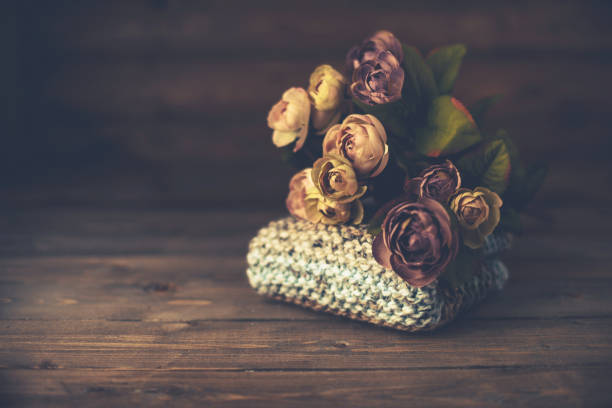 Still life background with hand knitted blanket and rose bouquet